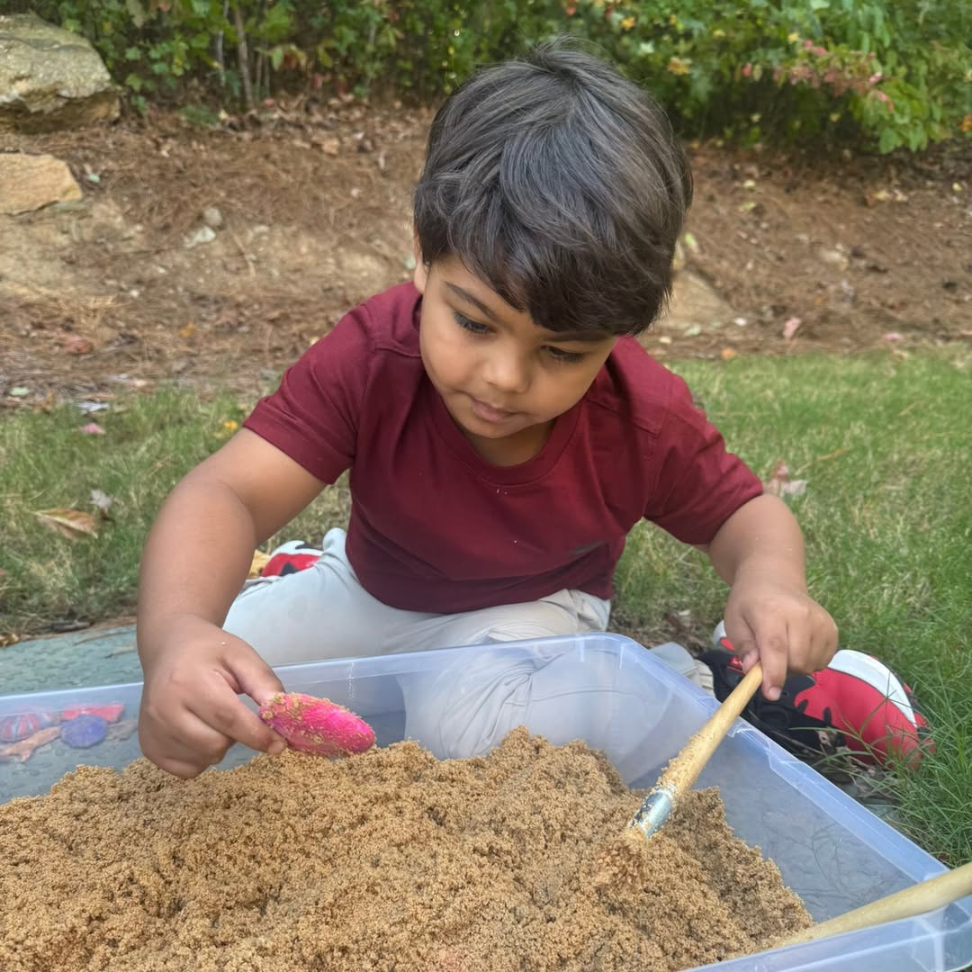 Student digging in a sand bin